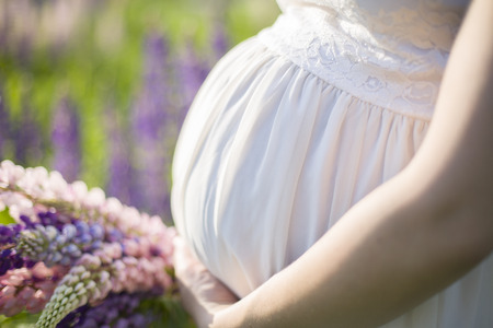 pregnant woman belly with bunch of flowers