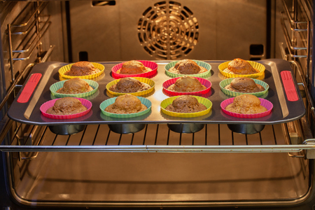Cakes in molds on a tray after baking in the ovenの写真素材