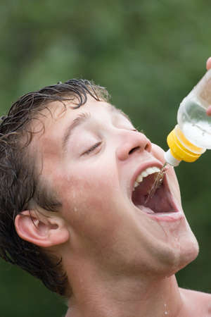 The guy drinking water from a bottle in the hot summer