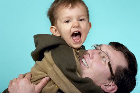 Father playing with his son, holding him in her armsの写真素材