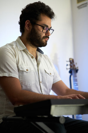 musician with piano playing music in studio