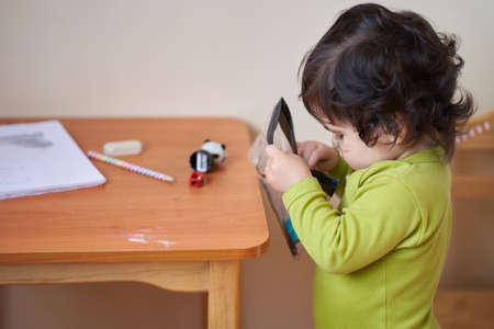 boy in green T-shirt holds a stich in his hand to draw pencils. play activities.の写真素材