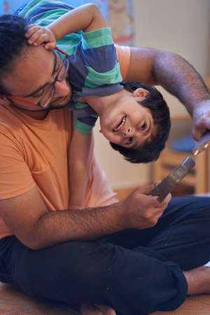 They are laughs over his father while trying to assemble furniture. Assembling furniture at home. Father sessionの写真素材