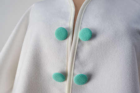 Buttons lined with calypso fabric on white coat. Authors design