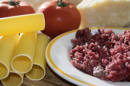 raw Cannelloni with minced and parmesan on a wooden backgroundの写真素材