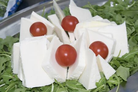 Slices of handmade pecorino with pachino tomatoesの写真素材