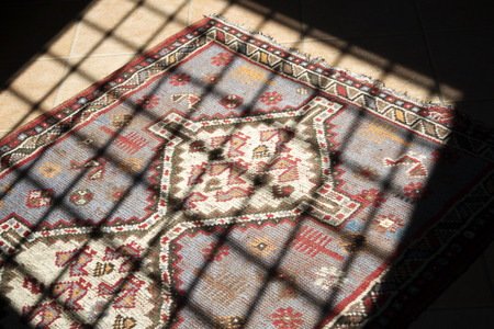 an oriental carpet of a home view through the grating of a windowの写真素材