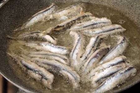 fillet of anchovies during the fry in a panの写真素材