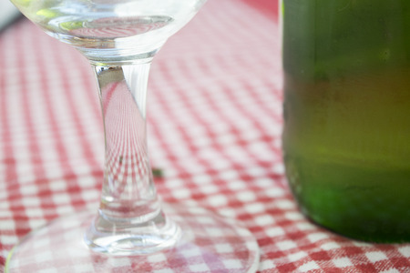 detail of the stem of a glass goblet beer with a hint of a beer bottleの写真素材