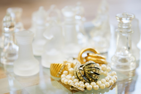 family jewels on a starfish between the pieces of a glass chessboardの写真素材