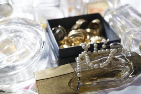 old and precious pearl necklace on a perfume bottle with gold family jewelsの写真素材