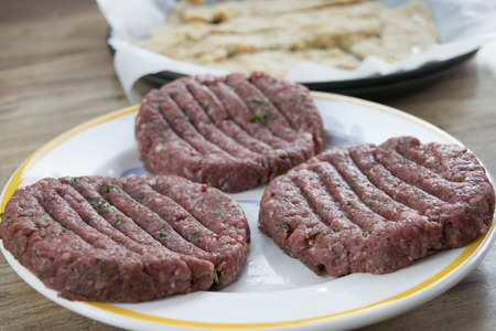 raw beef hamburger with aromatic herbsの写真素材