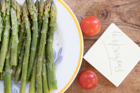 bunch of steamed asparagus with the writing on the post-itの写真素材