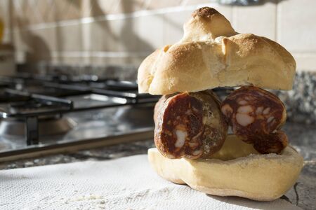 typical italian rosetta or roll filled with soppressata salamiの写真素材