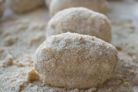 preparation of sicilian arancine with breadcrumbs on a paperの写真素材