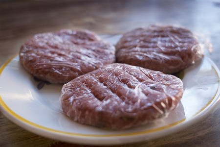 frozen meat hamburger wrapped in plastic filmの写真素材