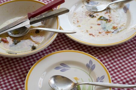 scraps left over and dirty dishes after dinnerの写真素材