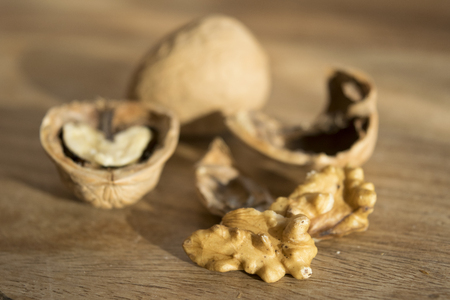 shells and kernels of walnuts on wooden background