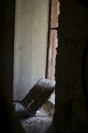 wicker basket in demi-light on a window of an old hutの写真素材
