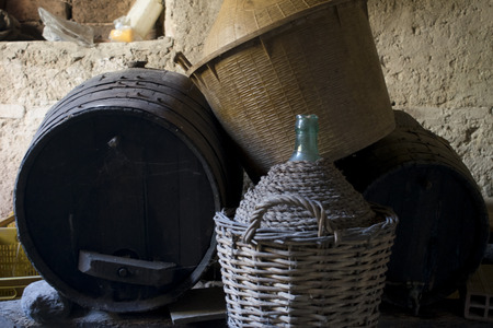 old underground cellar with demijohns and bottles of aged wineの写真素材