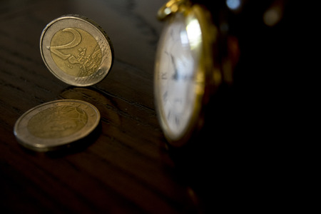 time and business management with an old watch and some money