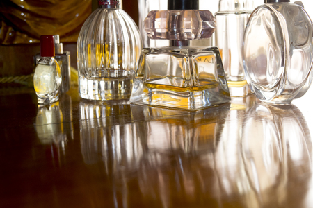 perfume bottles in back-lit on a wooden background and reflections of lightの写真素材