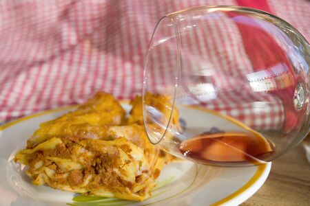 portion of lasagna at the bolognese sauce and balloon of red wineの写真素材
