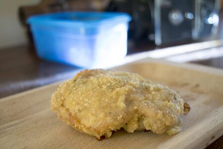 breaded baked chicken on a wooden dishの写真素材