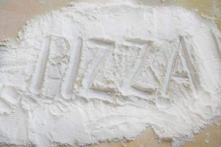 pizza written in the flour for a concept of the preparation of itの写真素材