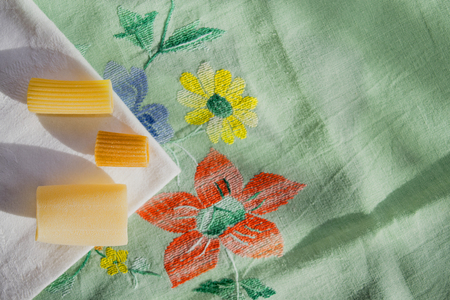 assorted raw pasta in sigle file on a colored table-clothの写真素材