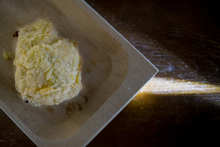 piece of breaded chicken on a wooden dish