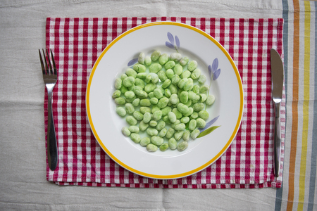 top view on frozen peeled broad beans in a white dishの写真素材