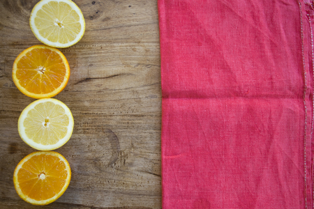 oranges and lemons cut half and neal a red napkinの写真素材