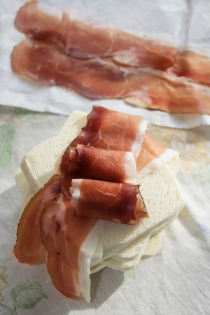 light meal consisting in a sandwich with italian speck or salted smoked hamの写真素材