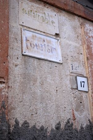 sustainable tourism with curious written on old road signsの写真素材