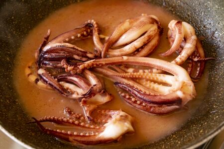 preparing stewed squid tentacles with tomato sauce