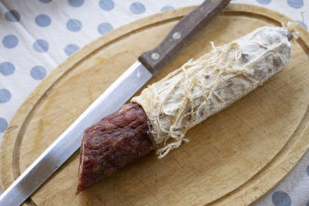 hot ungarian salami on a wooden cutting board