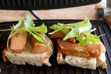 preparing toast made with bread wurstel and mixed green saladの写真素材