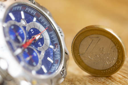 time is money with a watch and one euro