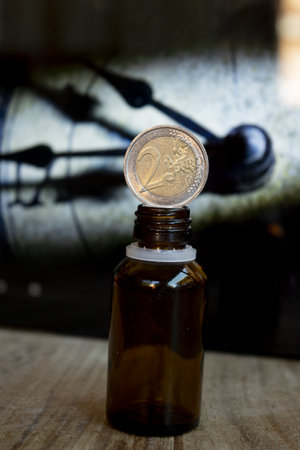 money on a medicine bottle with the detail of an old clock on the backgroundの写真素材