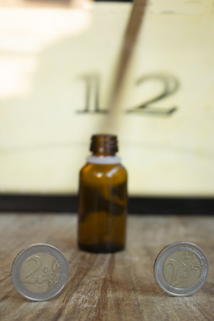 health time and wealth with a money and a medicine bottle with on the background an old clockの写真素材