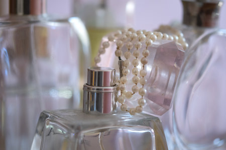 pearl necklace resting on perfume bottlesの写真素材
