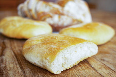 sliced bread and rolls placed on a cutting board