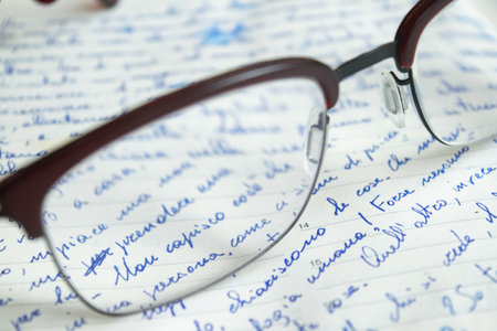 handwritten sheet with the writing seen through a pair of glassesの写真素材