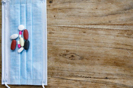 concept of health with a mask and the pills on the wooden table