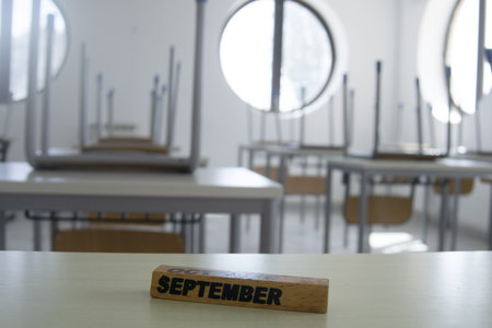 empty school classroom with the word september on the chairの写真素材