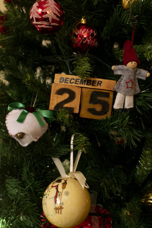 December 25 written on wooden dies and photographed in the middle of Christmas decorations