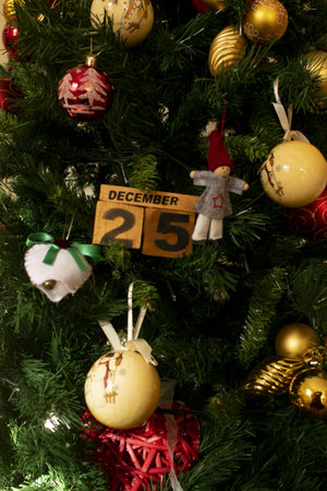 December 25 written on wooden dies and photographed in the middle of Christmas decorations