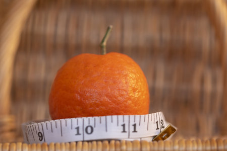 slimming diet and wellness with a mandarin surrounded by a meterの写真素材