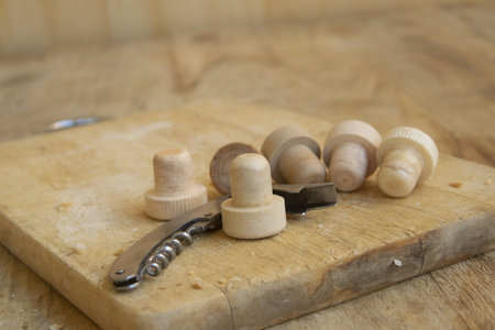 metal corkscrew with glass and cork stopper on a wooden cutting boardの写真素材